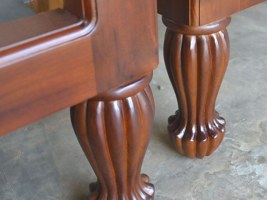 Front view of the teak tub chair, solid wood side frames profiled at the left and right.