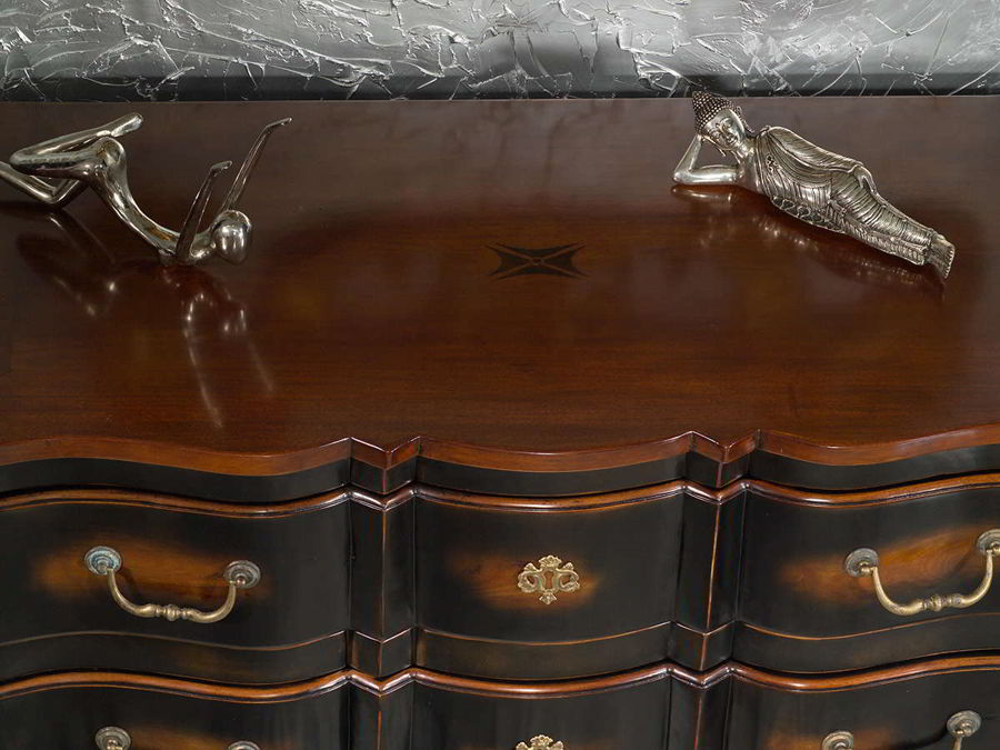 The beveled edges and curves of the bottom apron, the fake lock as accent on the center of drawer.